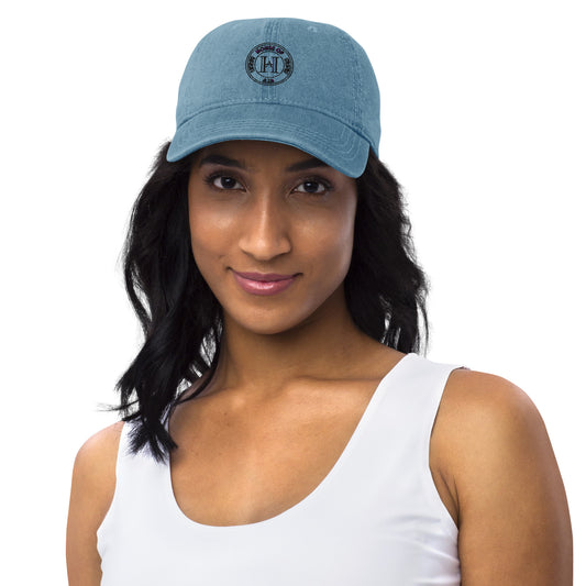 Indian woman wearing a jean hat featuring the House of Aja brand logo